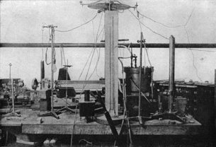 A photo of Millikan’s original lab bench shows the parallel plate chamber he used to determine the elementary charge.