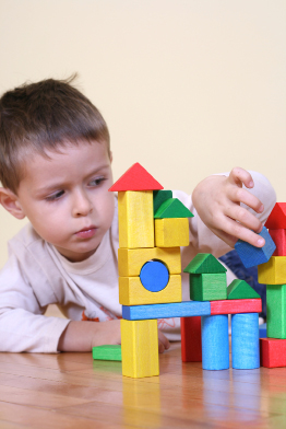 This photo shows a young boy creating an elaborate block structure.