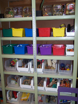 This photo shows a shelving unit with many bins containing toys and other items.