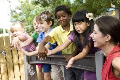 This photo shows several young children of diverse ethnic backgrounds playing together.