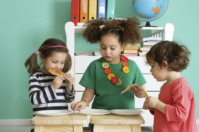 Lunch is one of the physical routines for children in a child care setting. In this photo, three children are eating pizza.