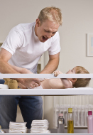 In this photo a child care provider changes a baby’s diaper.