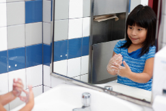 A child is pictured washing her hands.