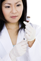 In this photo a health professional is shown extracting a vaccine from a vial.
