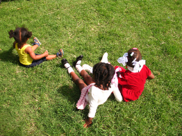 In this photo, three children are playing in the grass.
