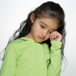 Exposure to family violence can have long-lasting effects on children. In this photo a young girl wipes away a tear.