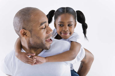 In this photo a child receives a piggyback ride from an adult.