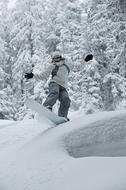 This is a picture of a snowboarder sliding on a ridge. 