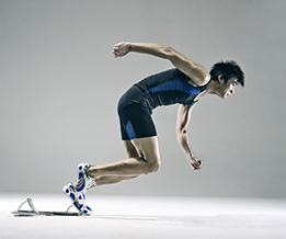 This is an image of a young man in starting blocks for a running race.