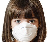 This is a photo of a young girl wearing a particle mask and looking worried.