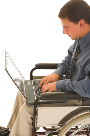 An image shows a young man in a wheelchair using a laptop.