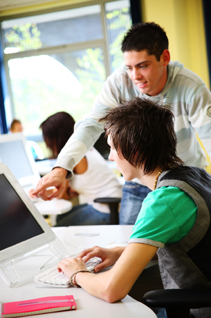 A photograph shows two students working on a computer together. 