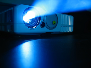 An image shows an LCD projector turned on and shining it's light.