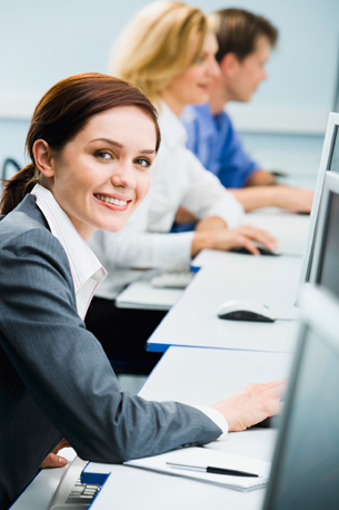 A photograph shows several students sitting in front of computers.