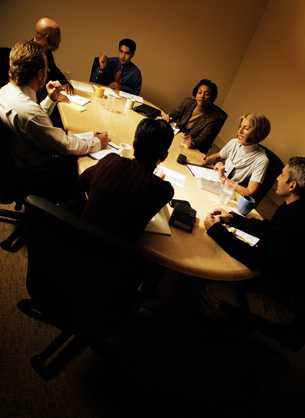 Photo of seven people having a meeting.