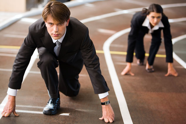 A young man and a young woman in suits are ready to start running a race in this photograph.