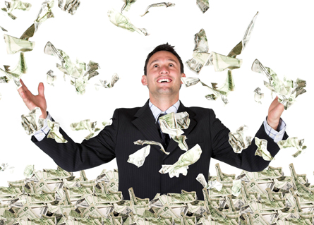 A young man surrounded in cash with more falling from above.