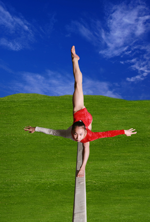 A gymnast balancing on one leg on a balance beam.