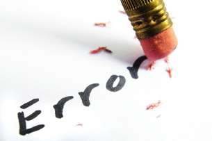 Close up of a pencil erasing the word “error.”