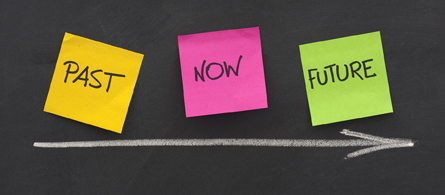 This image shows a simple timeline labelled past, now, and future.The words past, now, and future are written on yellow, pink, and green sticky notes, respectively, and a chalk arrow points to the right.