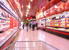 This photograph shows shoppers in the dairy and meat sections of a supermarket.
