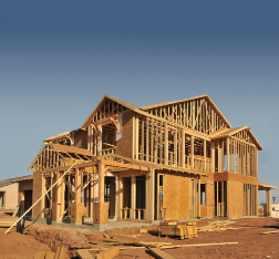 This photograph shows the wooden frame of a house under construction.