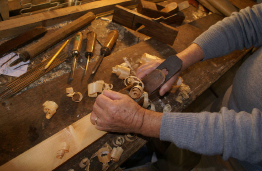 This photograph shows a carpenter planing wood.