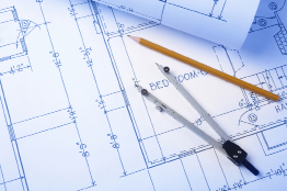 This is a photo of house blueprints with a compass and pencil laying overtop.