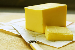 This photograph shows a pound of butter and a butter knife.