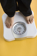 This shows a person weighing herself on a bathroom scale.