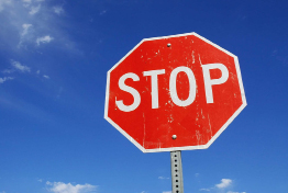 This photograph shows a stop sign against a blue sky.