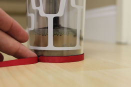 A photograph shows a ribbon wrapped once around the base of a glass cup.