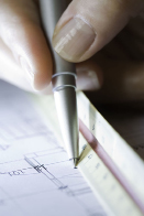 This photo shows a ruler being used to measure a distance on a blueprint.