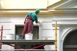This photo shows a worker repairing the exterior of a home.