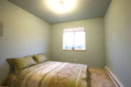 This is a photograph of a bedroom with a larger window.