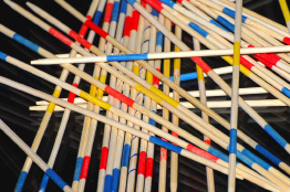 This is a photograph of pickup sticks scattered on a black surface.