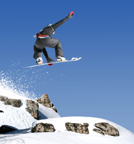 This is a photograph of a snowboarder against a blue sky.