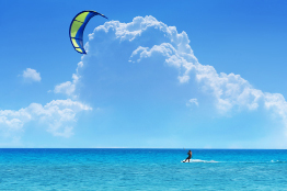 The kiteboarder in this photo is using a blue and yellow kite.