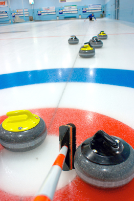 This photo is of a broom next to a rock during a curling game.