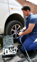 A photo shows a young man installing tires using an impact wrench.