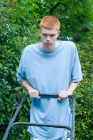 This is a photo of a young person mowing the lawn.