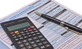 A photo shows an application for income-tax deductions, a calculator, and a pencil.