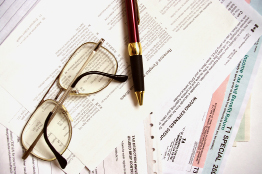 This is an image of a tax document, a pen, and glasses.