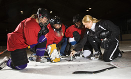 This photo shows a coach talking with a hockey team.
